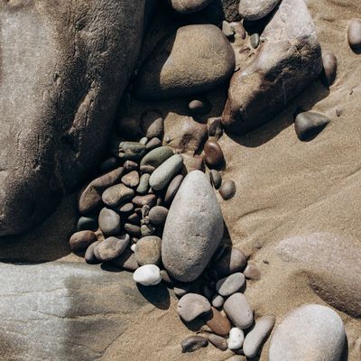 A smooth stone balanced on top of another stone.